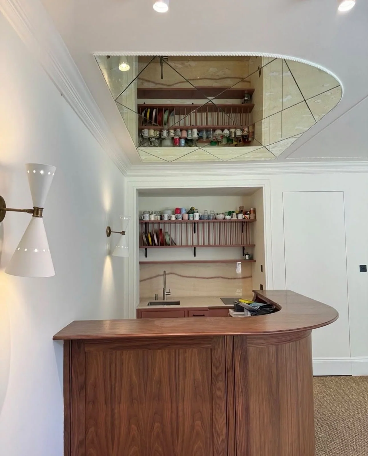 Home bar with a walnut counter and mirrored back shelves