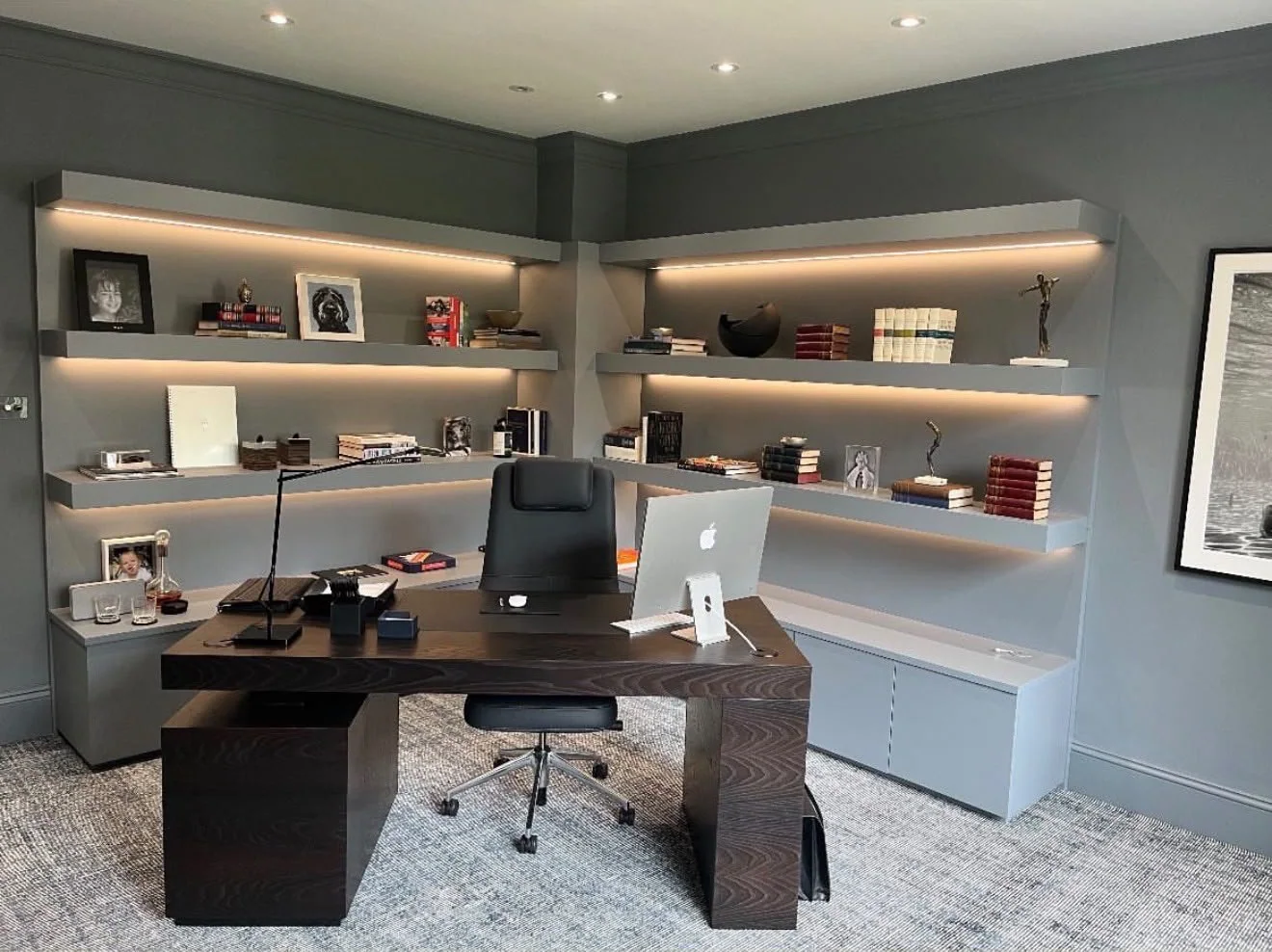 Home office with lit floating shelves around the walls