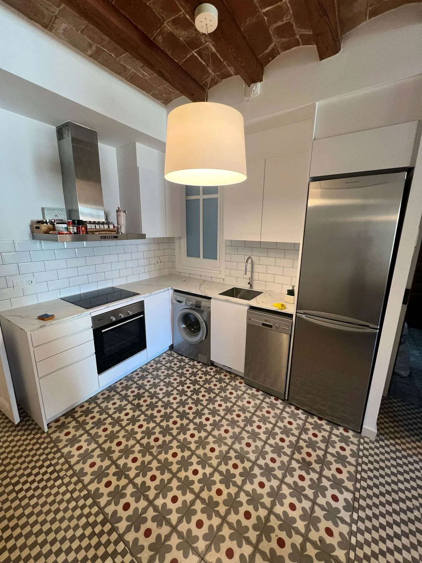 Kitchen with a patterned tile floor under a vaulted ceiling
