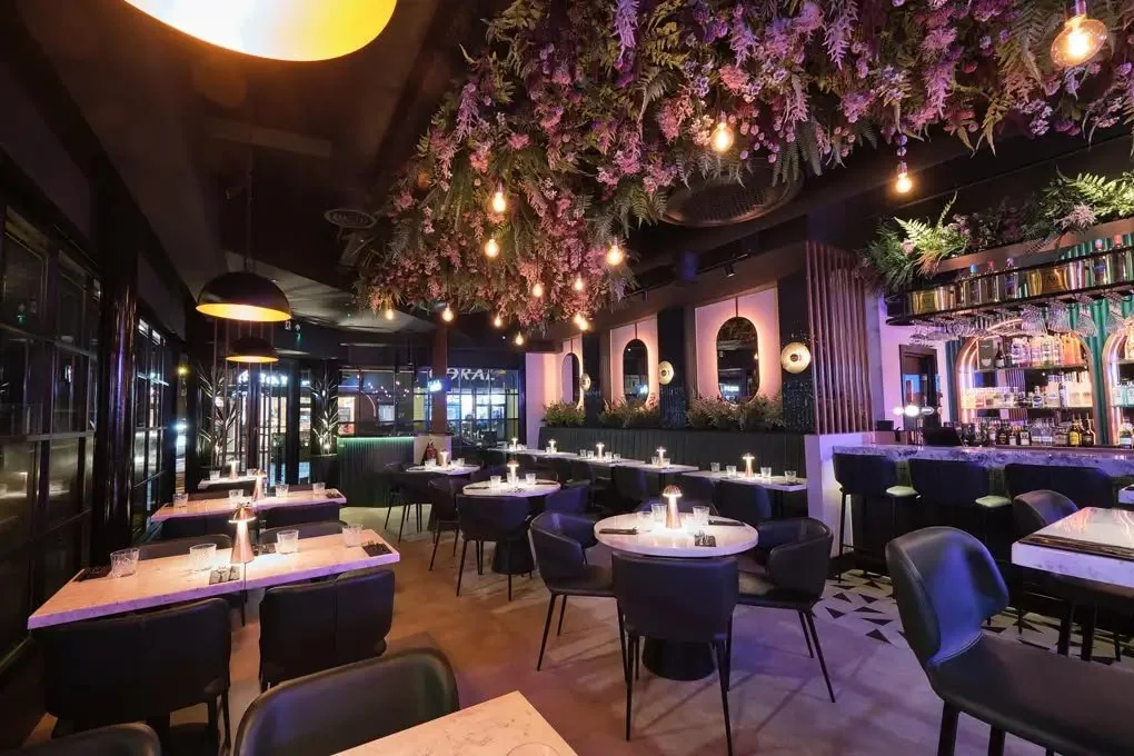 Restaurant and bar with booth seating and a hanging floral ceiling