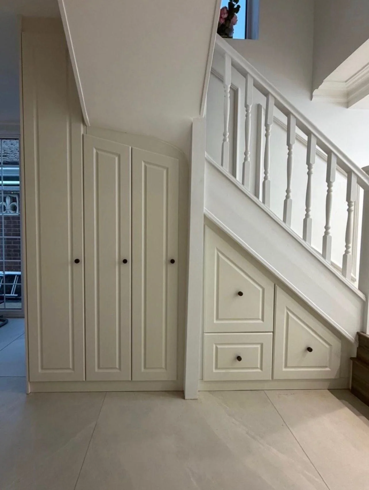 Under-stairs cupboards and drawers in a hallway