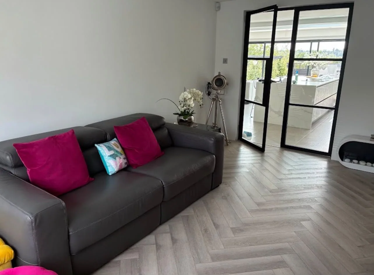 Open-plan living room with a pale herringbone floor